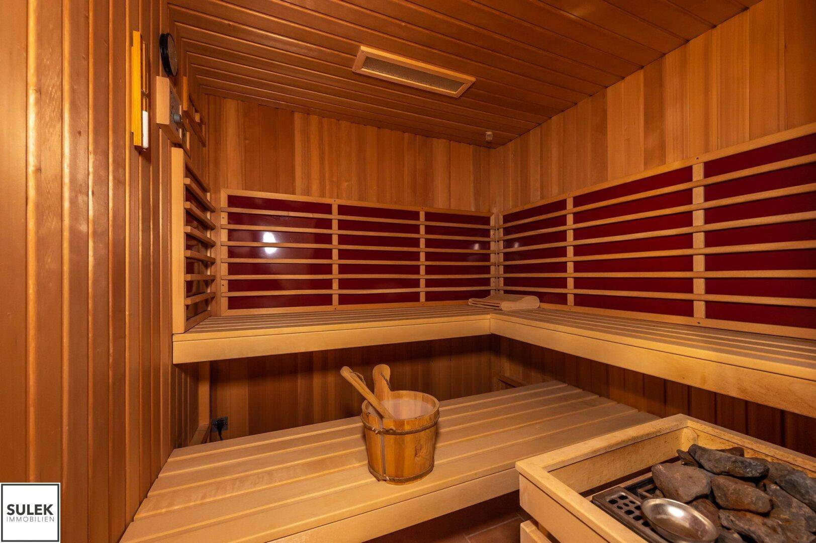 Traditionelle Holzsauna mit Bänken und Saunaofen für entspannende Wellness-Momente im eigenen Zuhause.