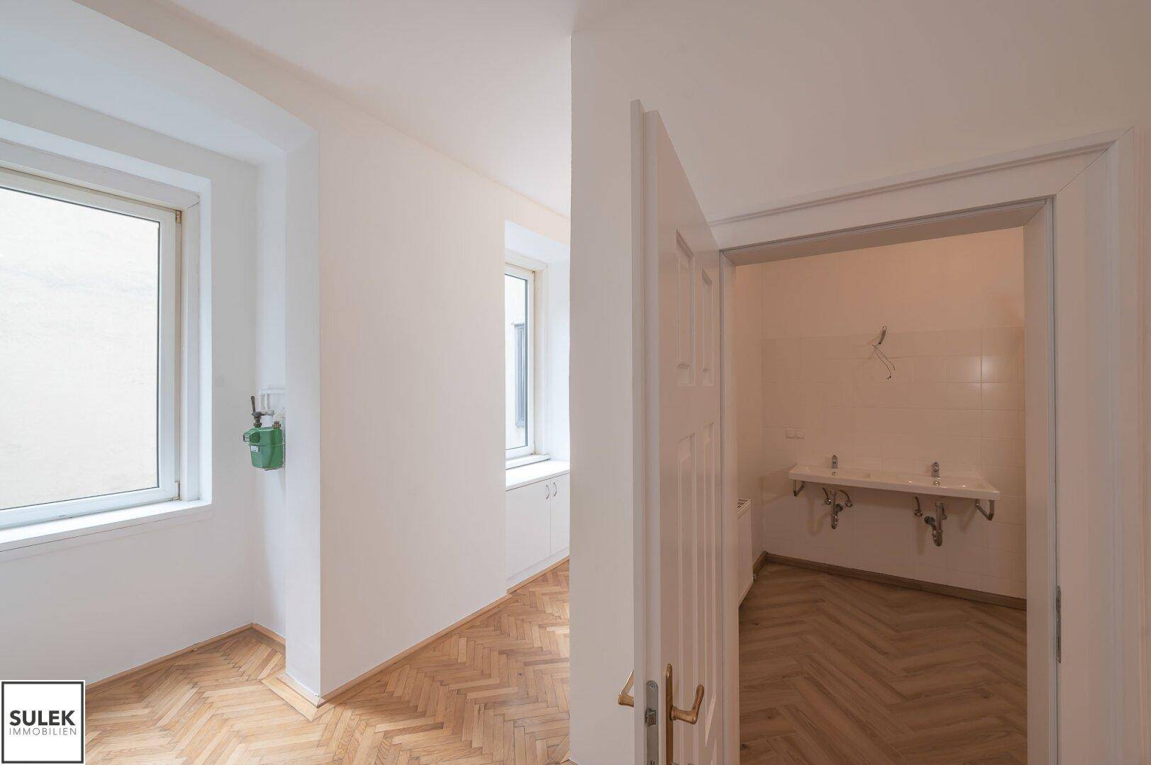 Badezimmer mit zwei Waschbecken und einer offenen Duschkabine, bereit zur Fertigstellung.