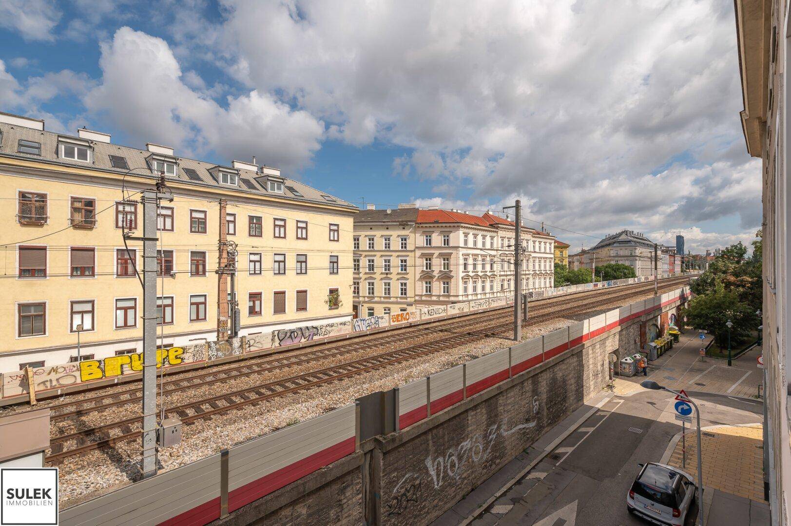 Weitblick über die Bahngleise und die städtische Bebauung mit historischer Architektur.