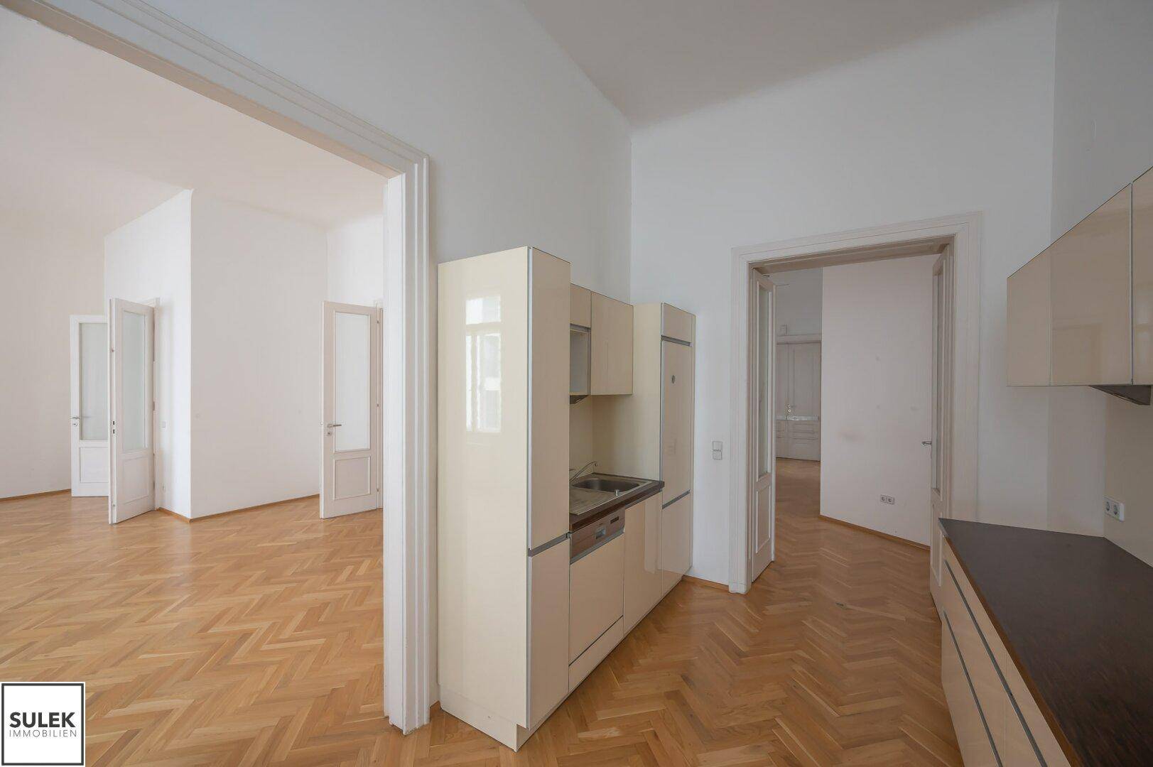 Kompakte Küche mit Einbauschränken und direktem Zugang zu den Wohnbereichen.