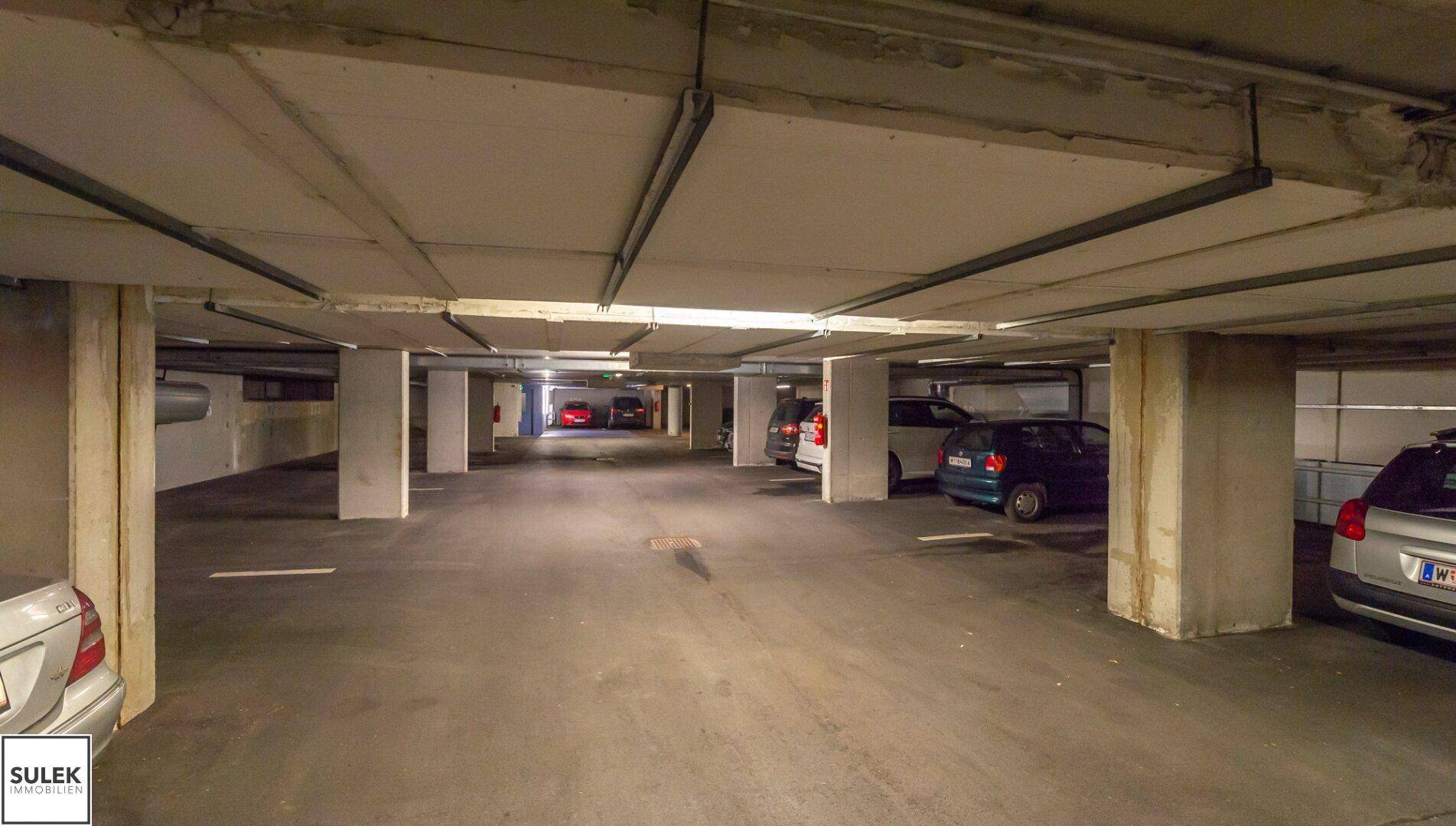 Weitläufige Tiefgarage mit vielen Stellplätzen und Betonpfeilern.