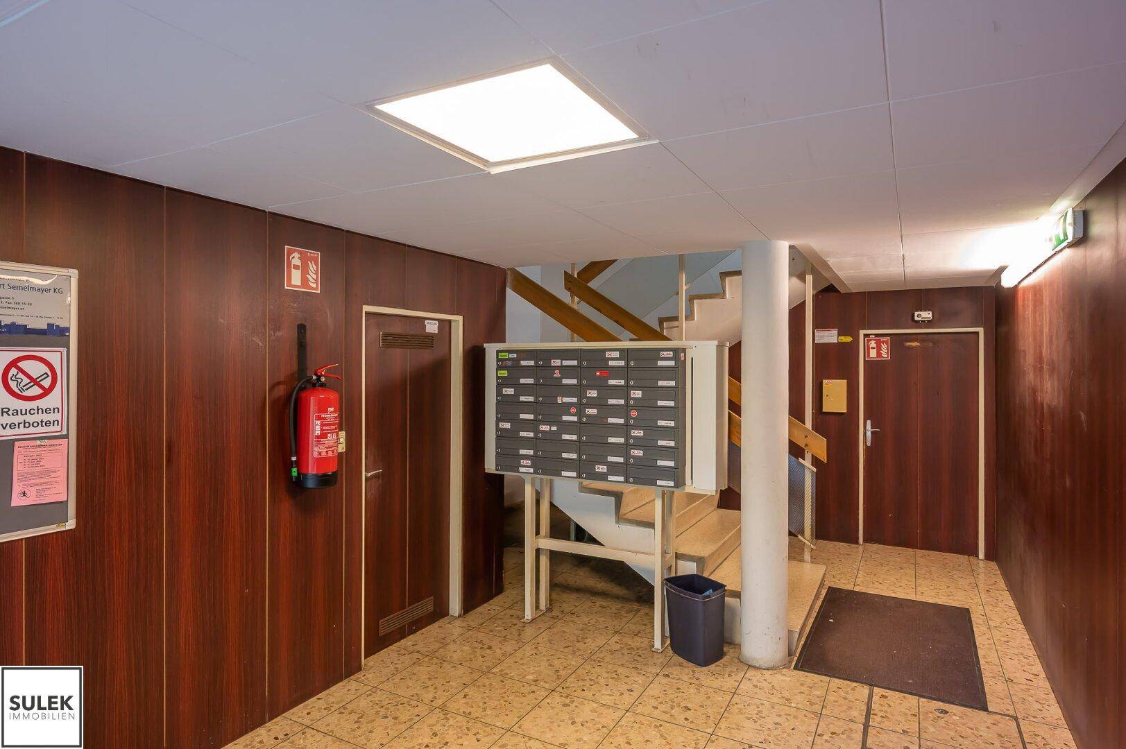 Eingangsbereich des Mehrfamilienhauses mit Briefkästen und Treppenaufgang.