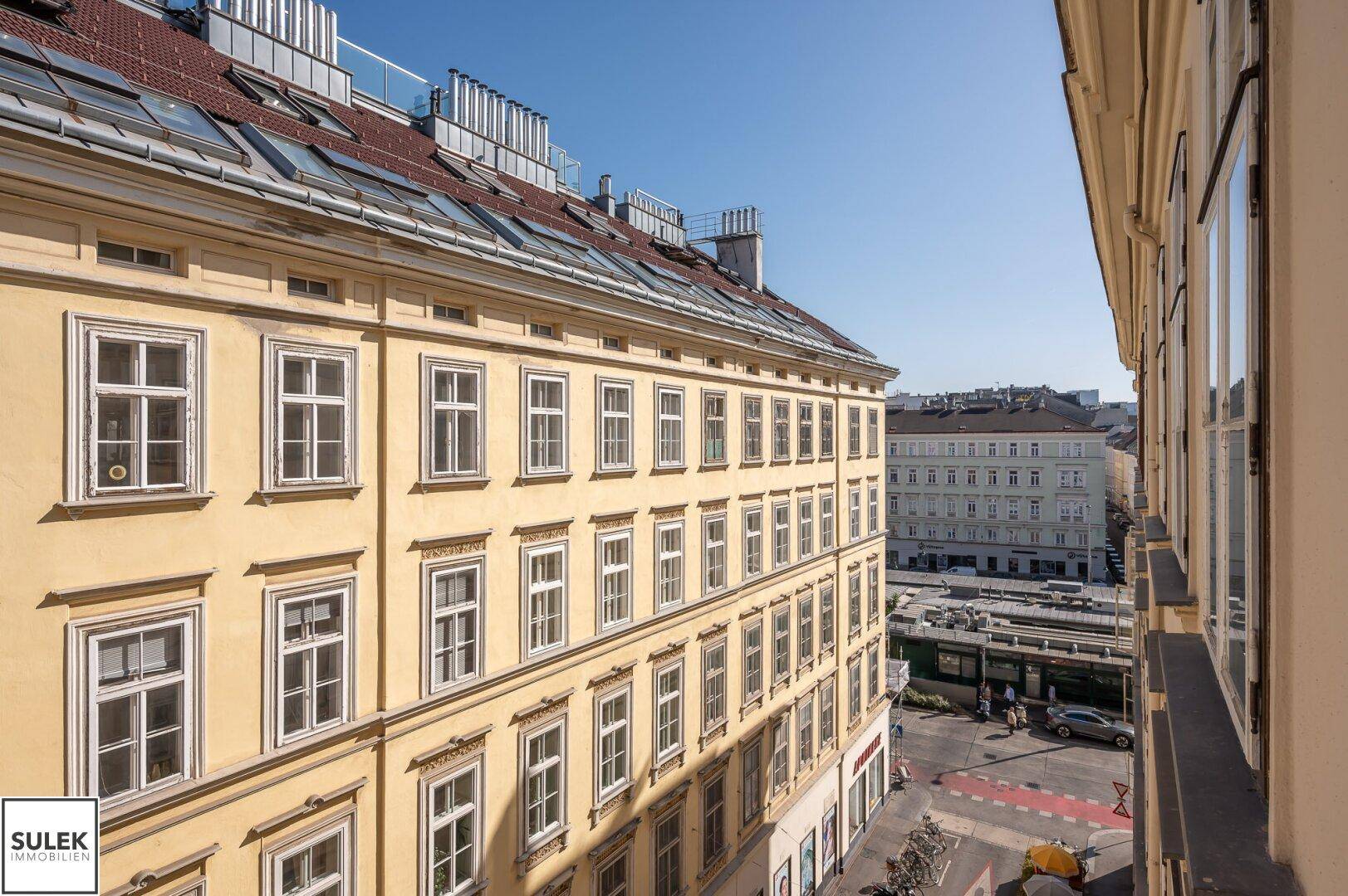 Blick auf die historische Stadtarchitektur mit gelben Gebäuden und einem klaren blauen Himmel.