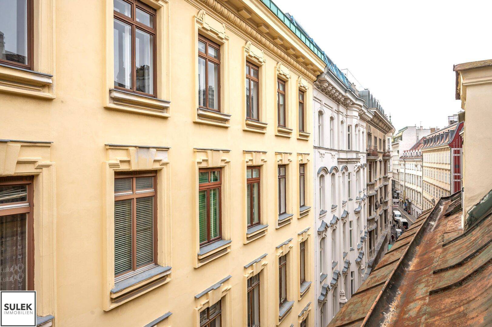 Historische Gebäudefassaden mit vielen Fenstern und traditionellen Dächern in einer Stadtansicht.