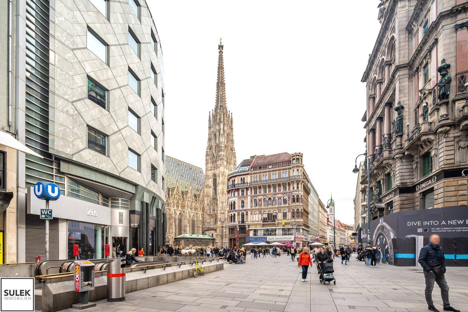 Weitläufige Stadtansicht mit dem Stephansdom, modernen Gebäuden und belebten Plätzen.