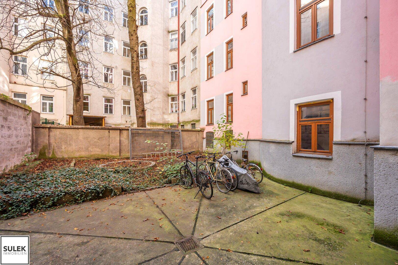 Innenhof mit Grünflächen, Fahrradabstellplätzen und Blick auf die umliegenden Gebäude.