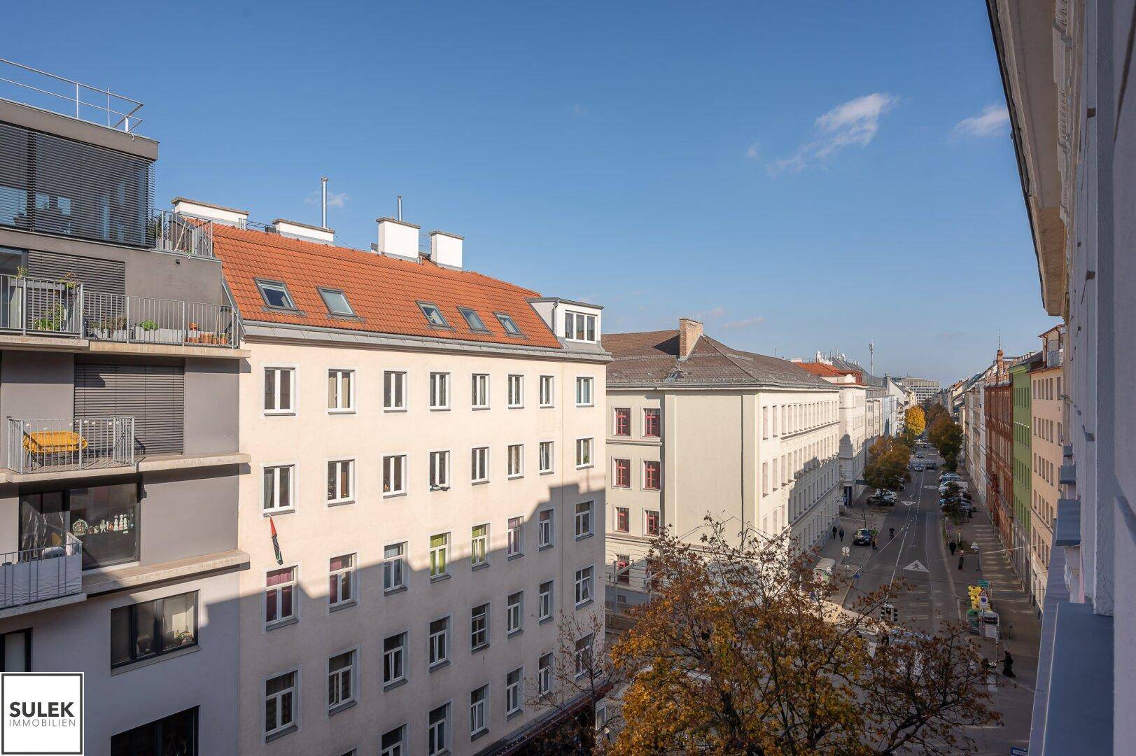 Panoramablick über die Stadt mit verschiedenen Gebäudetypen und einer belebten Straße.