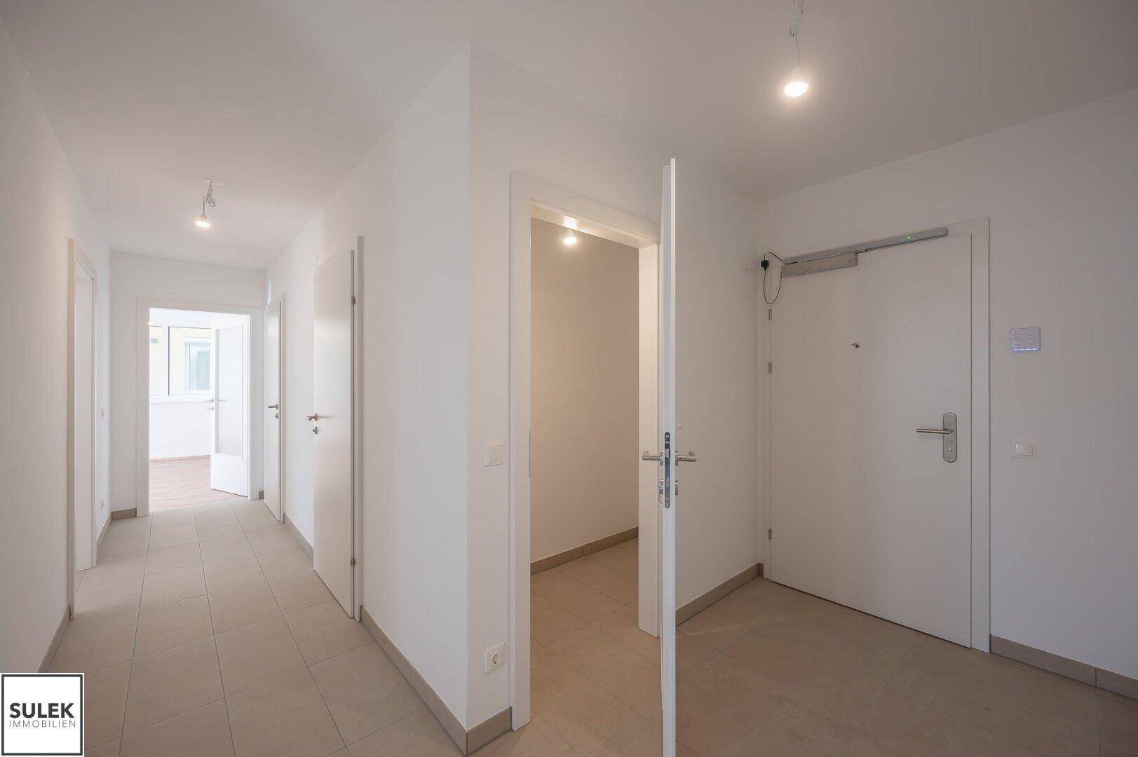 Heller Flur mit Fliesenboden und mehreren Türen, verbindet die verschiedenen Räume der Wohnung.