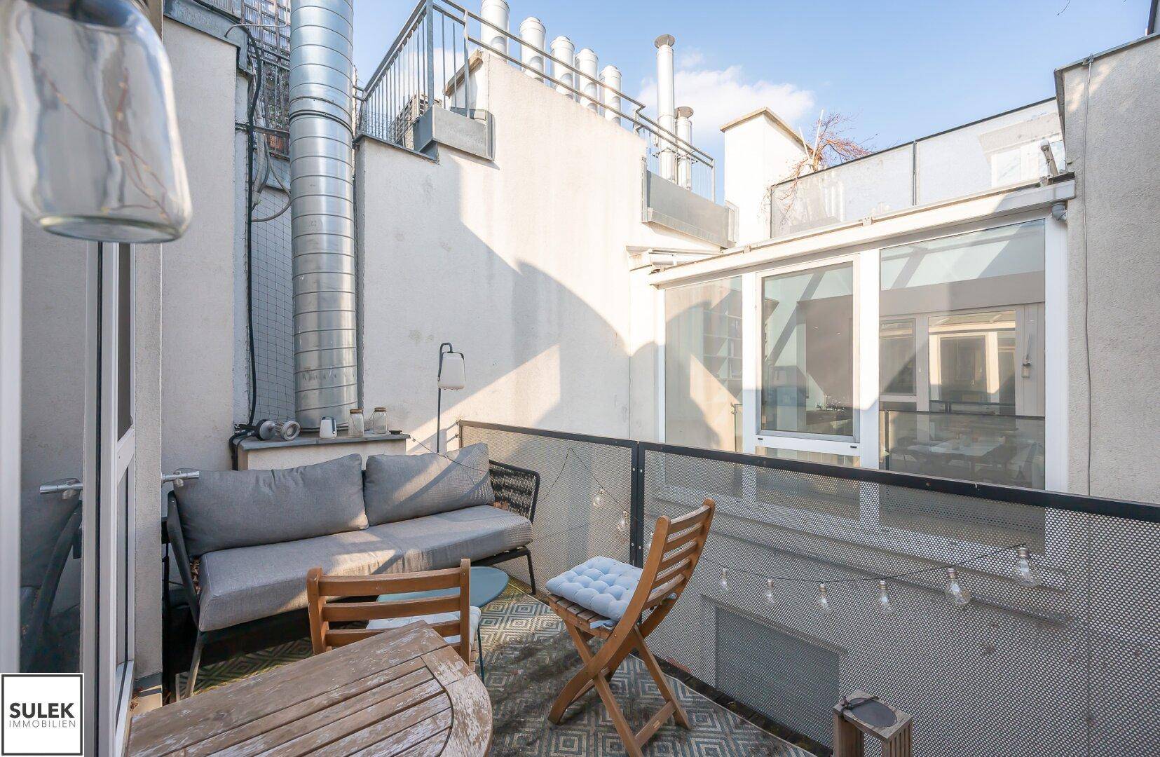 Kleiner, gemütlicher Balkon mit Sitzgelegenheiten und Blick auf die Umgebung.
