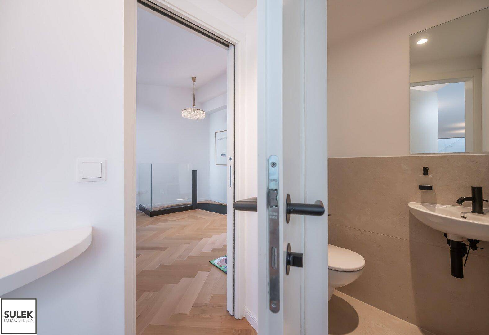 Modernes Gäste-WC mit Wand-WC und kleinem Waschbecken.