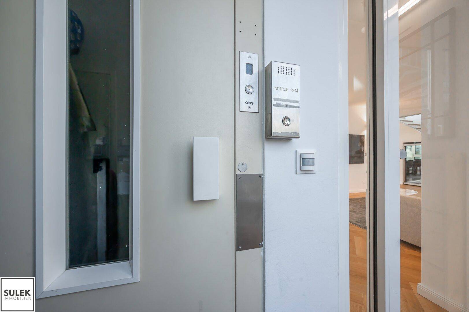 Eingangsbereich mit modernem Aufzug und Gegensprechanlage.