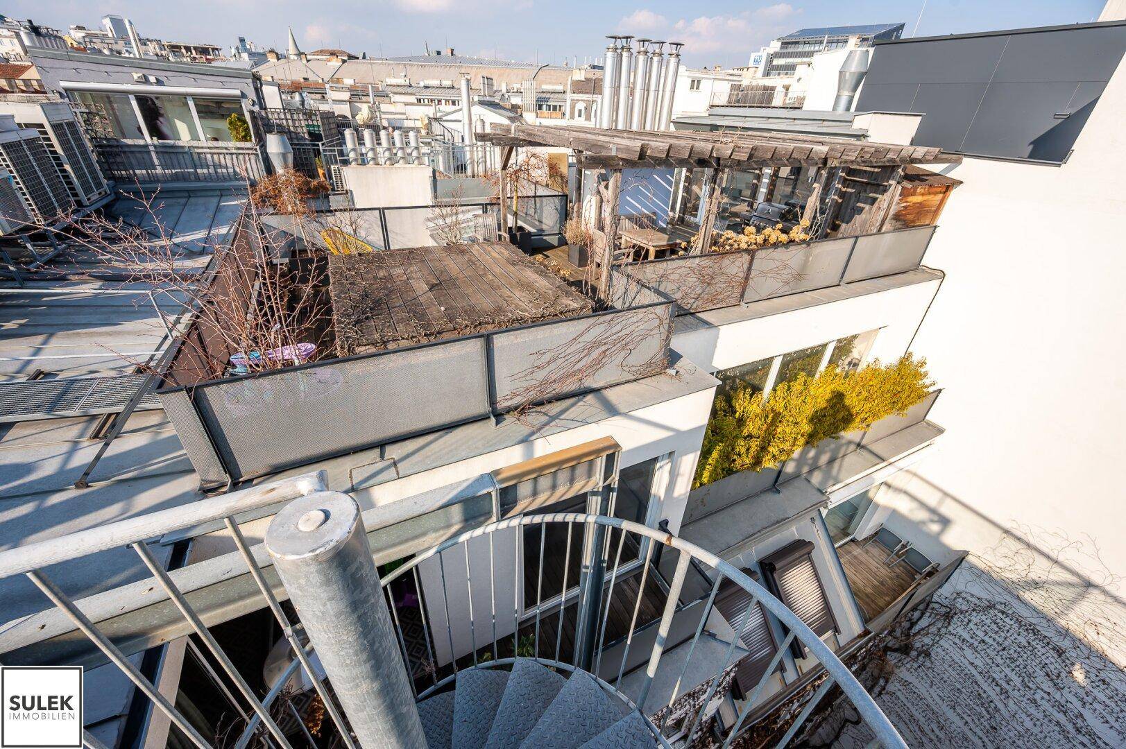 Dachterrassenlandschaft mit verschiedenen Ebenen und Wendeltreppen.