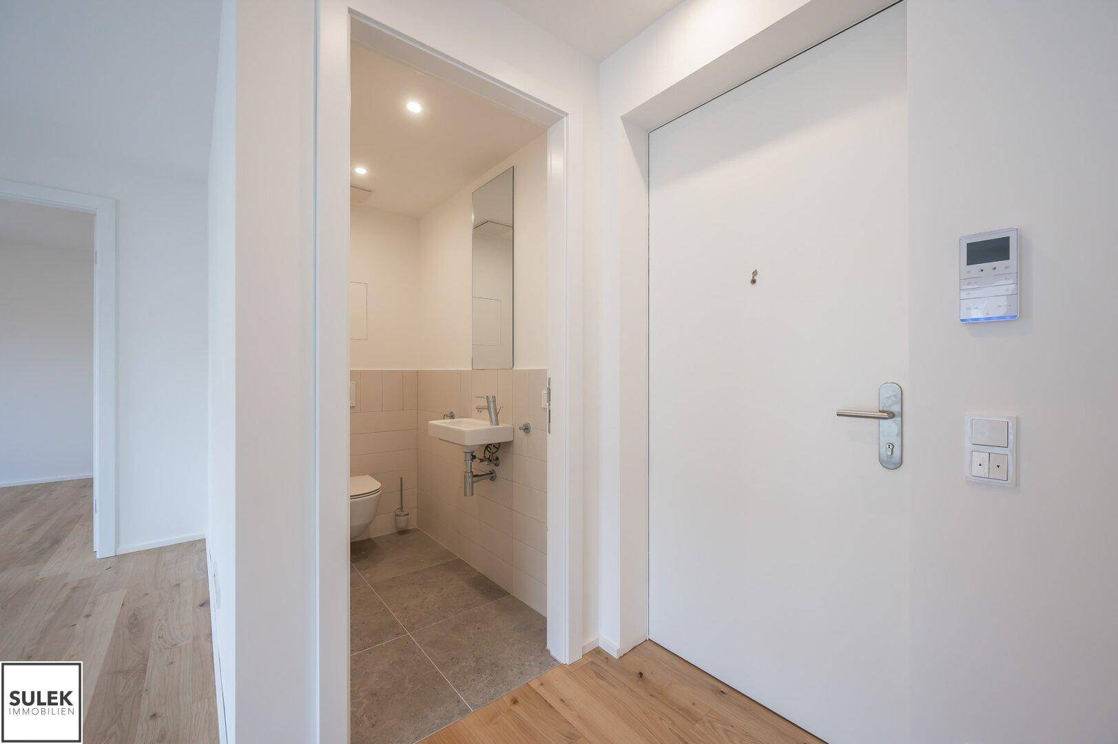 Kleines Gäste-WC mit modernem Waschtisch und Wand-WC im Eingangsbereich der Wohnung.