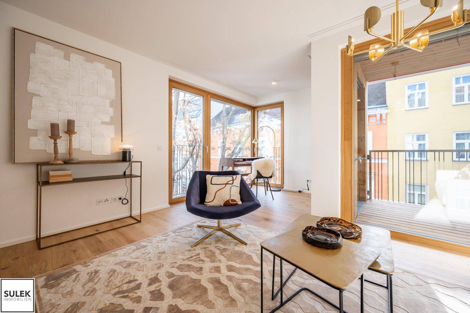 Geräumiges Wohnzimmer mit Holzboden, moderner Einrichtung und viel Tageslicht.
