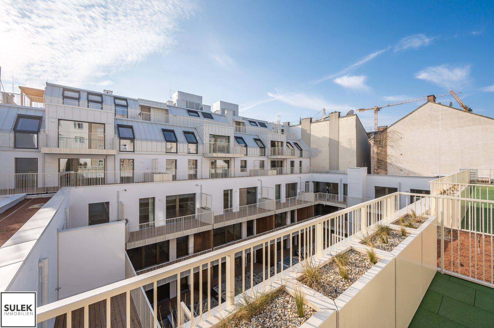 Dachterrasse mit Blick auf den Innenhof und die umliegenden Gebäude.