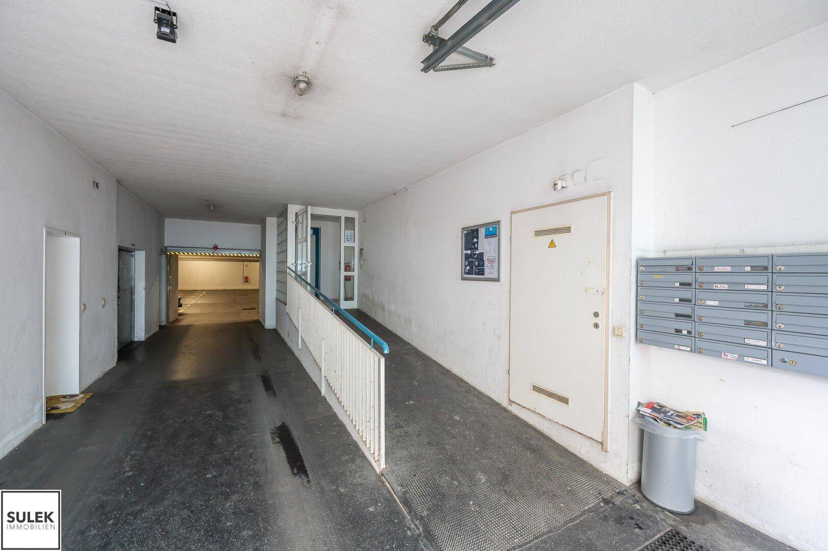 Eingangsbereich mit Rampe, Briefkästen und Zugang zur Tiefgarage des Gebäudes.