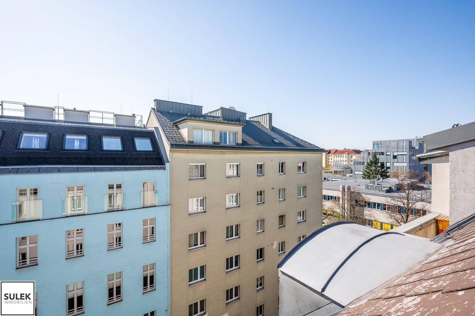 Panoramablick über die städtische Umgebung mit Wohngebäuden und einem blauen Himmel.