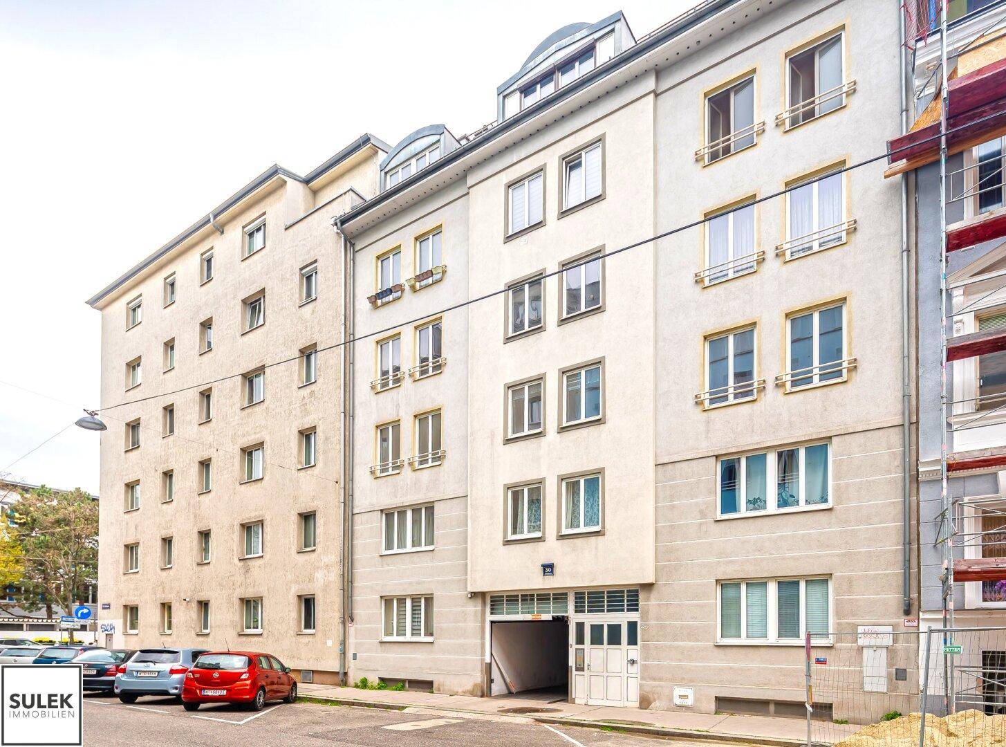 Fassade eines Mehrfamilienhauses mit vielen Fenstern und Eingangsbereich.