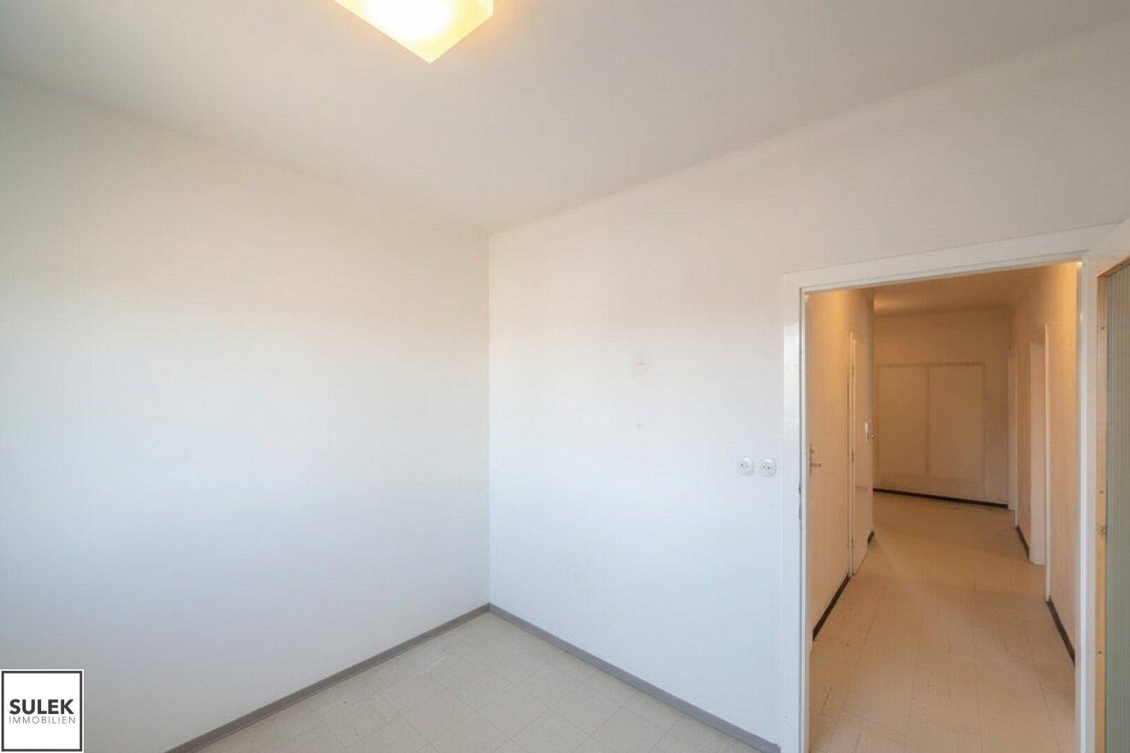 Heller Flur mit Fliesenboden und Zugang zu weiteren Zimmern der Wohnung.