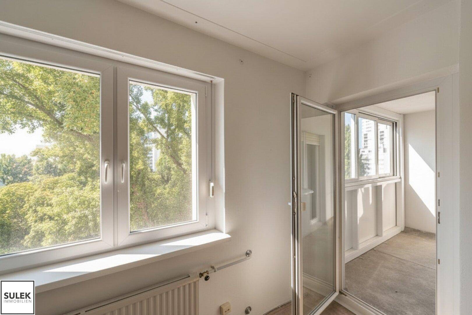 Verglaster Balkon oder Wintergarten mit Blick ins Grüne und auf die Stadt.