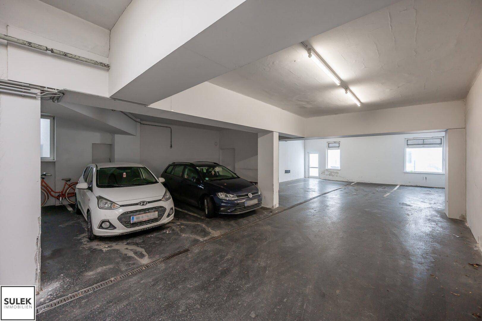 Geräumige Tiefgarage mit Betonboden und mehreren Stellplätzen für Fahrzeuge.