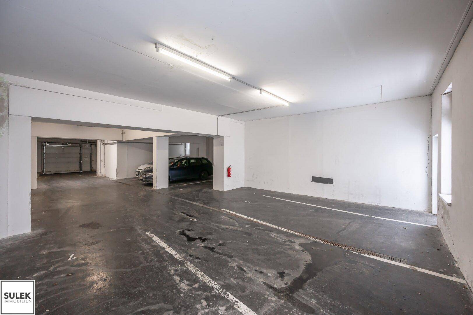 Weitläufige Tiefgarage mit Betonboden und markierten Stellplätzen, bereit zur Nutzung.
