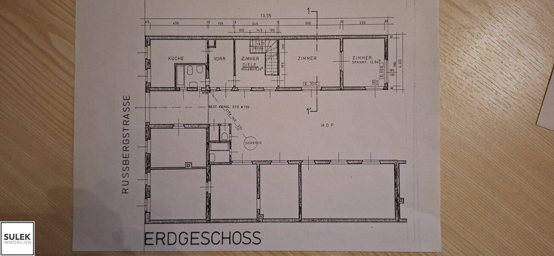 Grundriss des Erdgeschosses mit Zimmern, Küche und Hofbereich.