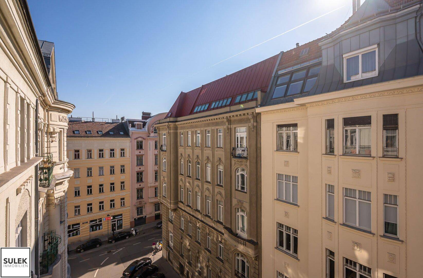 Panoramablick auf eine historische Stadtstraße mit traditionellen Gebäuden und sonnigem Himmel.