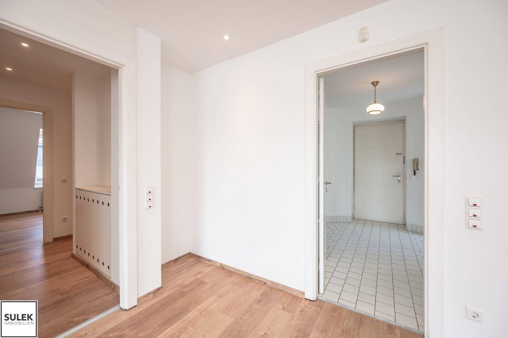 Heller Flur mit Parkettboden und Zugang zu verschiedenen Räumen der Wohnung.