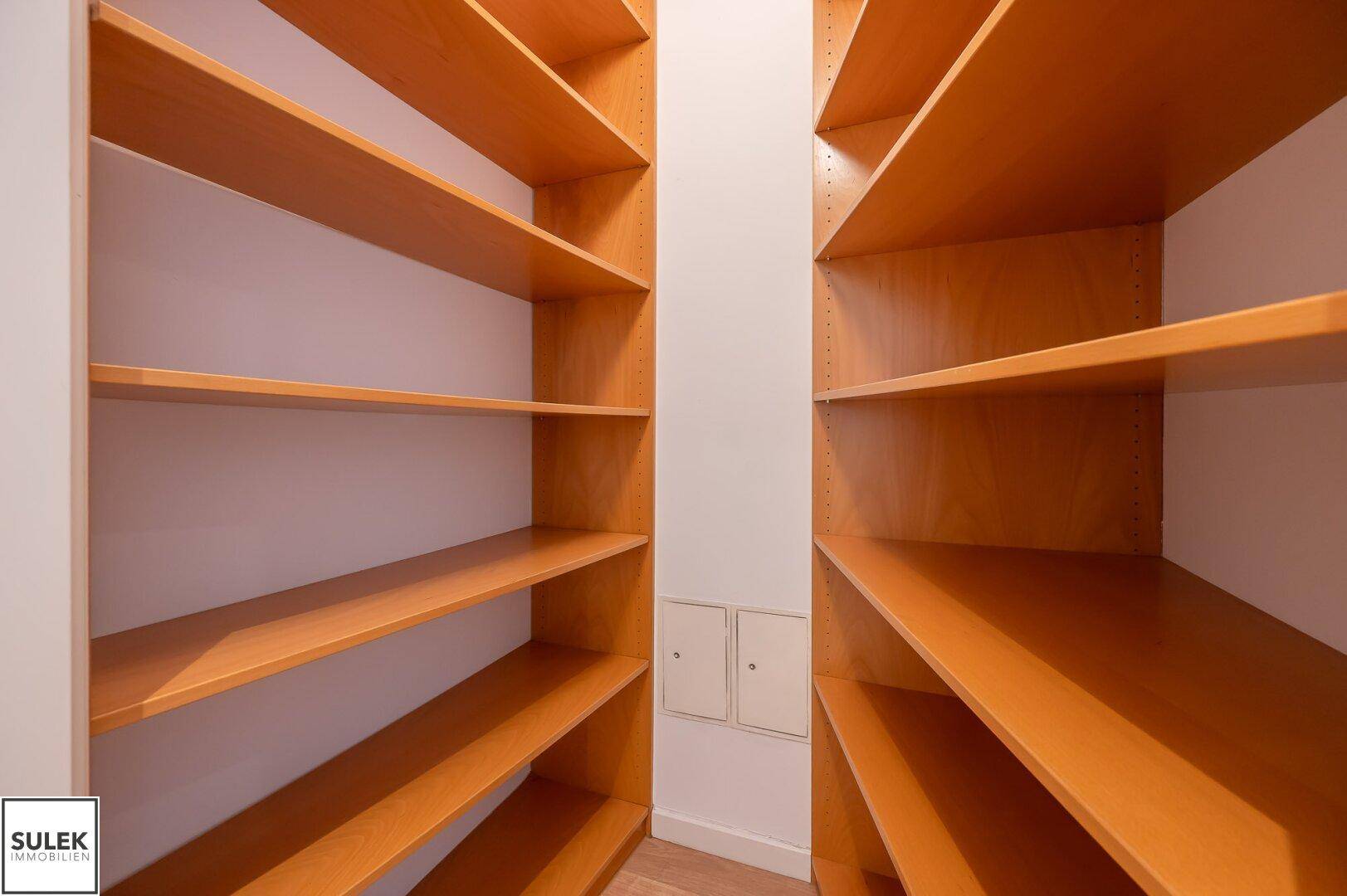 Praktischer Abstellraum mit vielen Holzregalen für zusätzlichen Stauraum in der Wohnung.