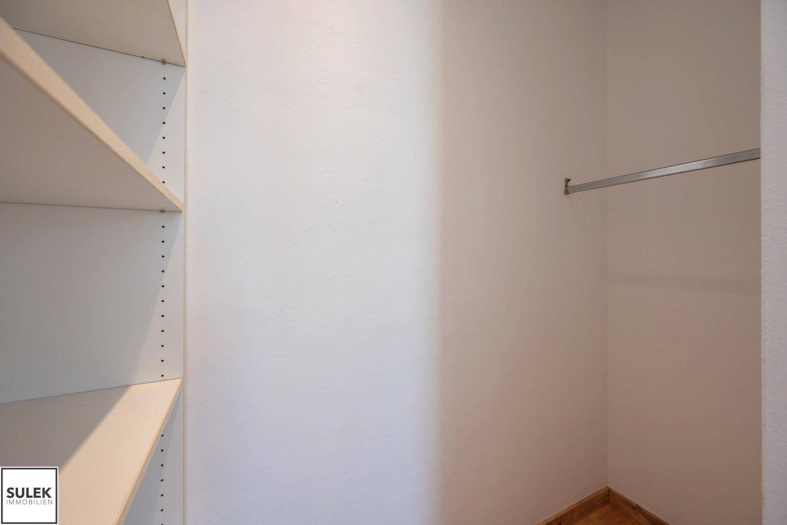 Praktischer begehbarer Kleiderschrank mit Regalen und Kleiderstange für Organisation.