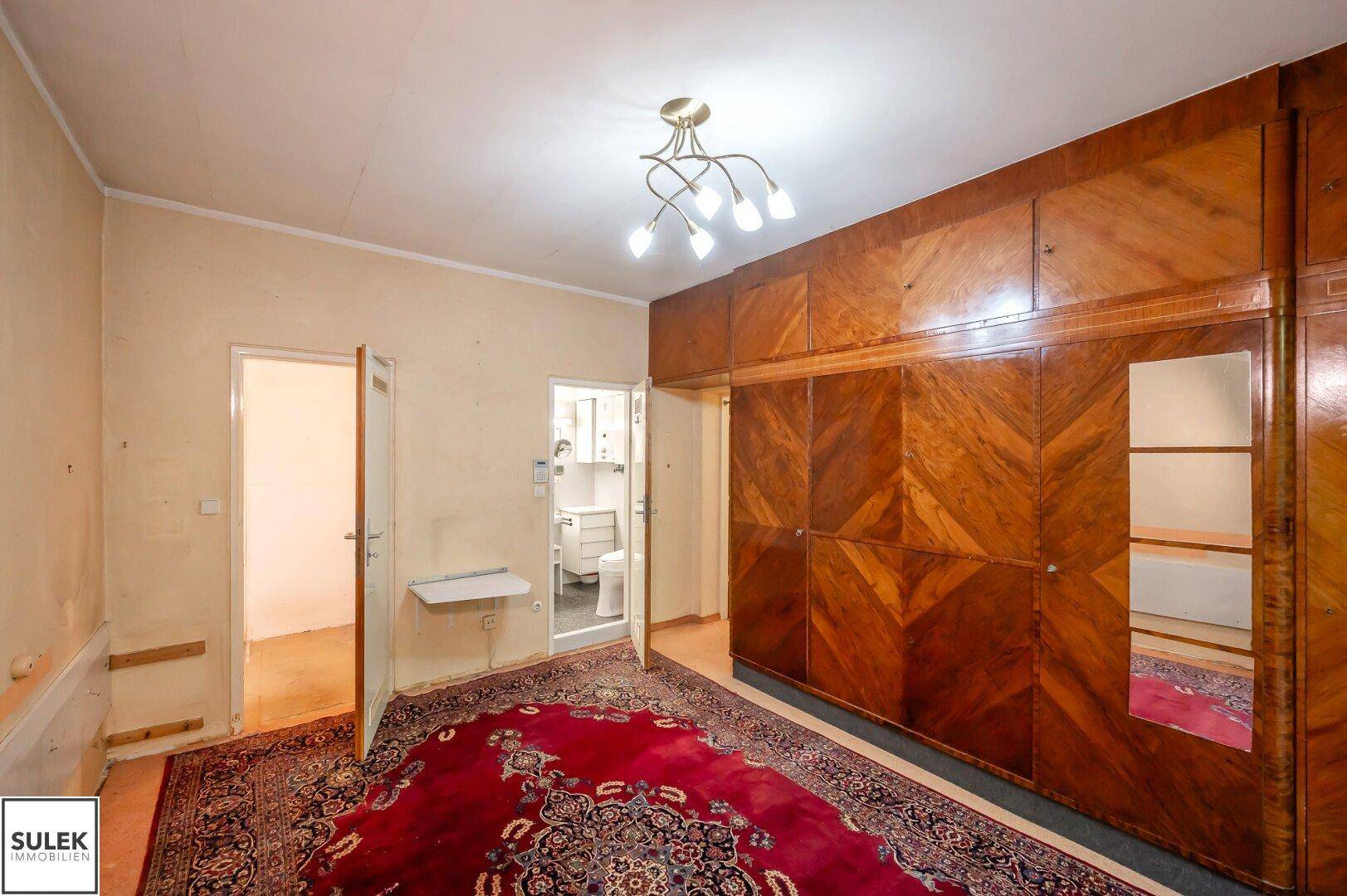 Schlafzimmer mit großem Einbauschrank und Zugang zum Badezimmer.