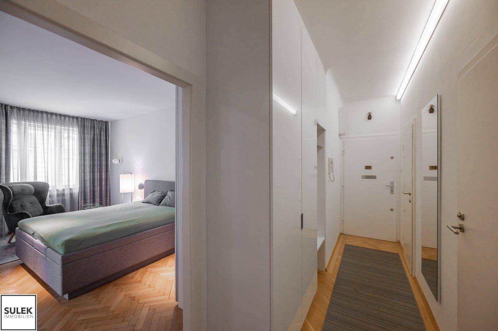 Heller Flur mit Garderobe und Zugang zu Schlafzimmer und Eingangstür.