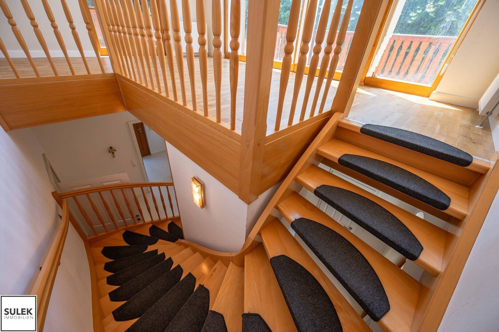 Holztreppe mit Teppichstufen, die die verschiedenen Ebenen des Hauses verbindet.