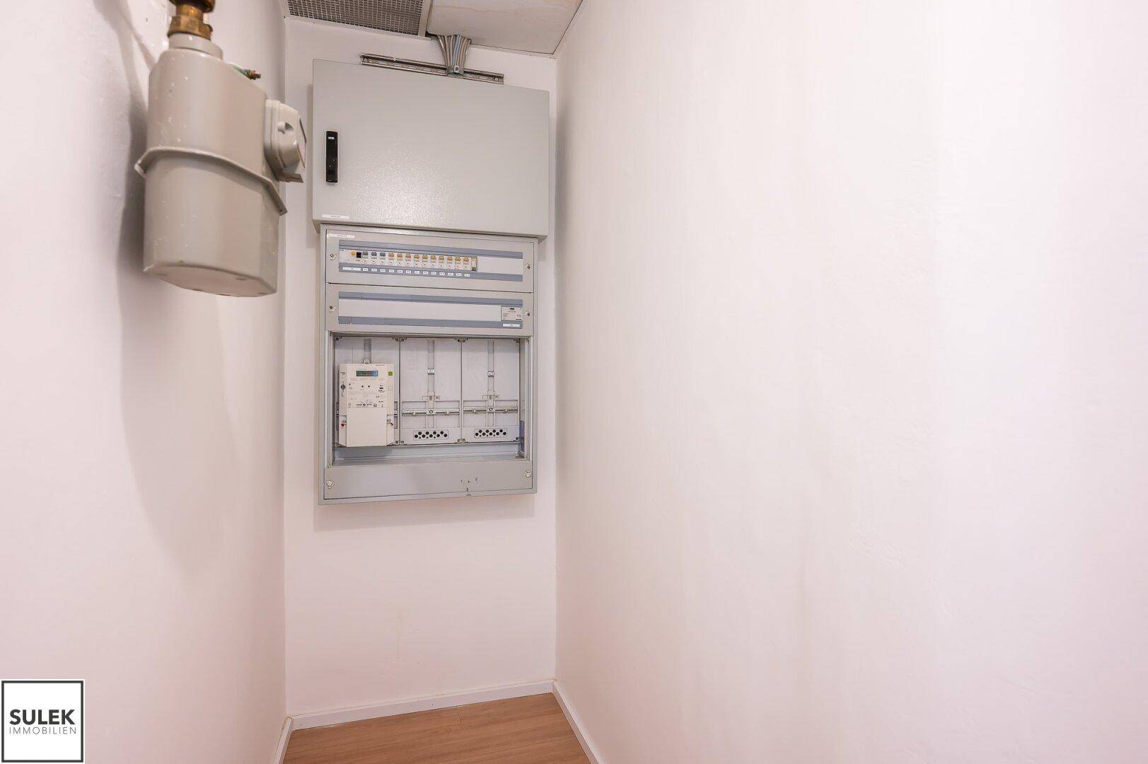 Kleiner Abstellraum mit einem Sicherungskasten und einem Gaszähler an der Wand.