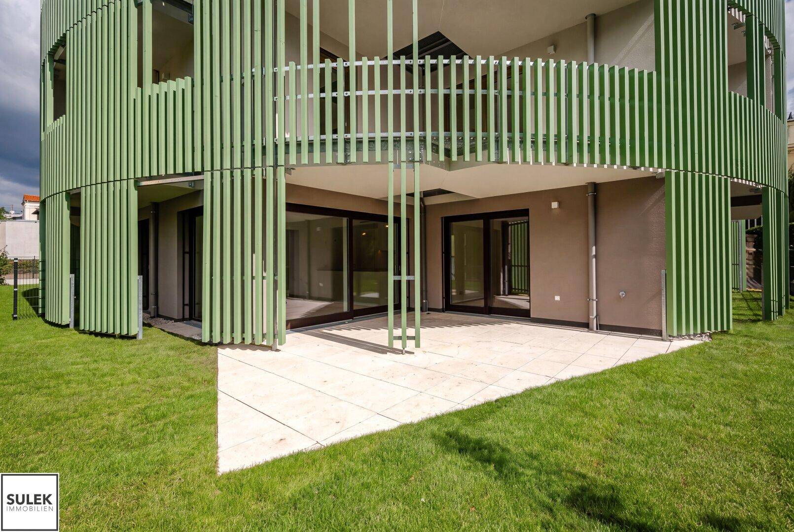 Großzügige Terrasse mit direktem Zugang zum Garten und moderner Fassadenverkleidung.