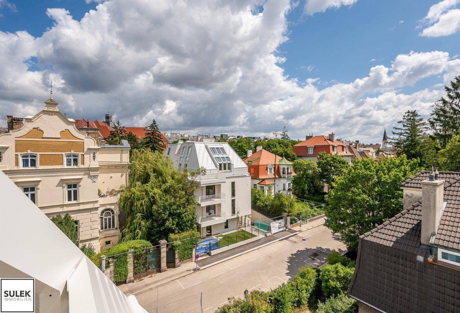 Panoramablick auf die Umgebung mit einer Mischung aus historischen und modernen Gebäuden unter bewölktem Himmel.