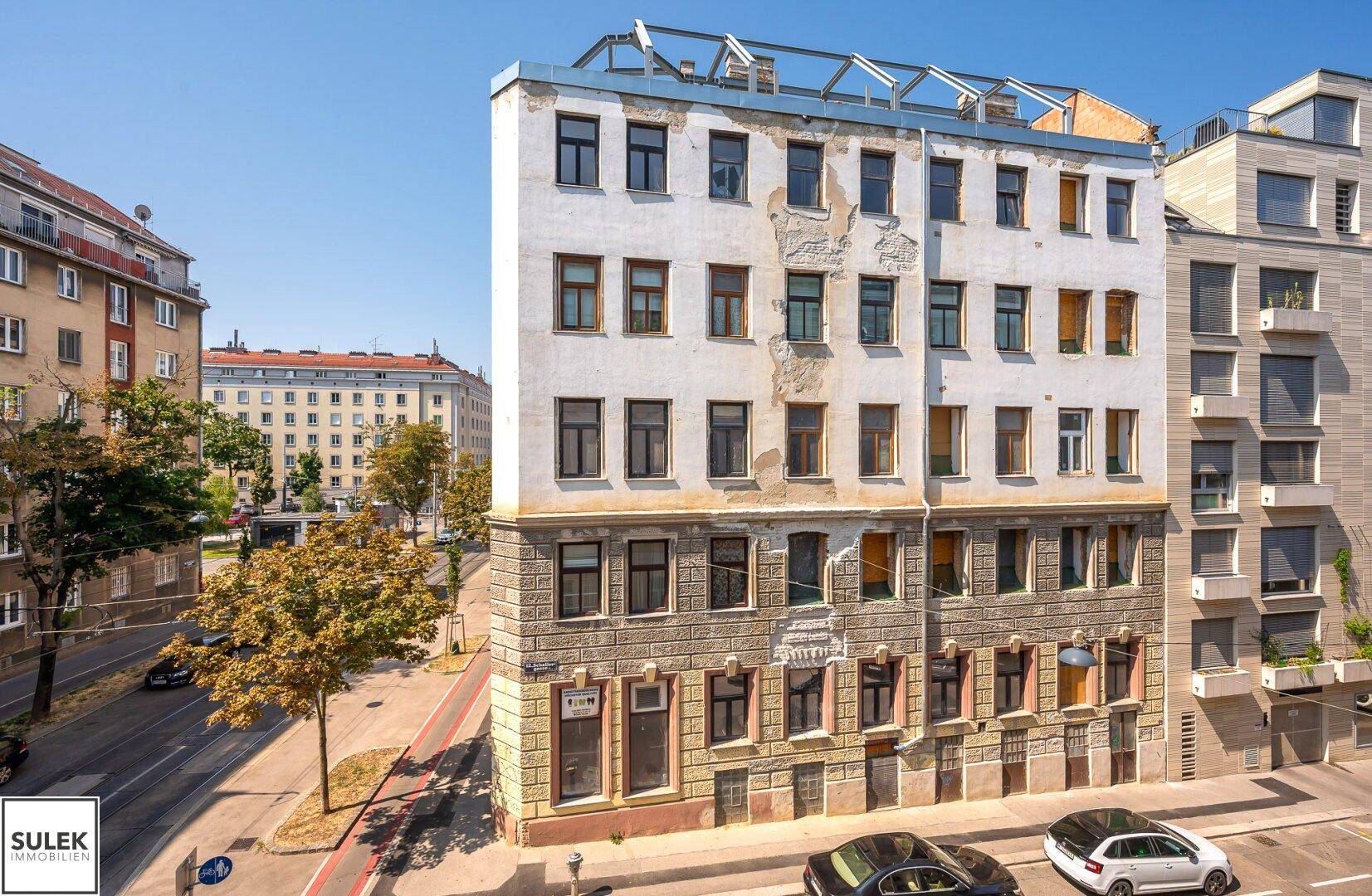 Historisches Gebäude mit renovierungsbedürftiger Fassade und Blick auf die Stadt.