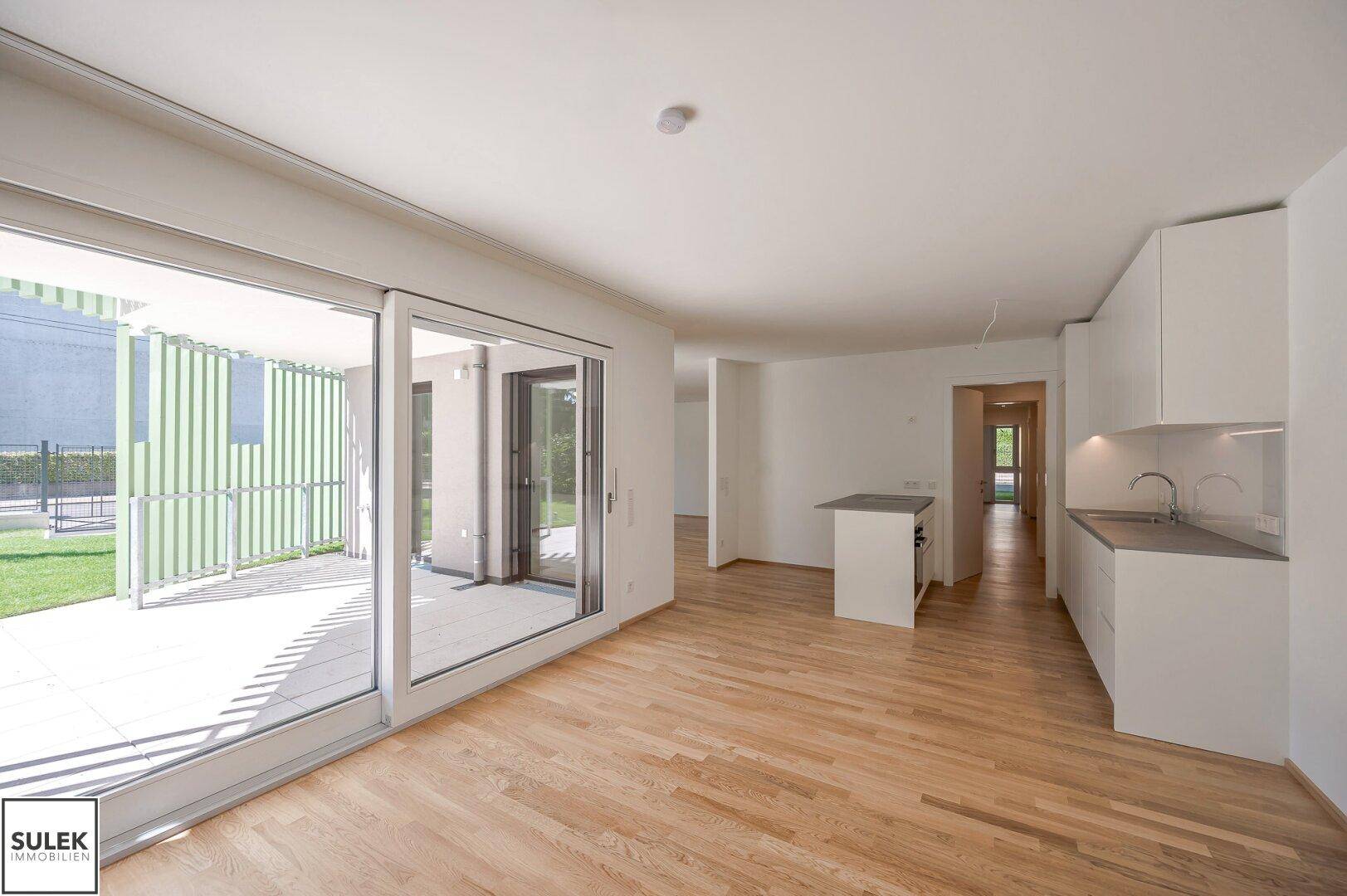 Geräumiger Wohn- und Essbereich mit offener Küche und direktem Zugang zur Terrasse.