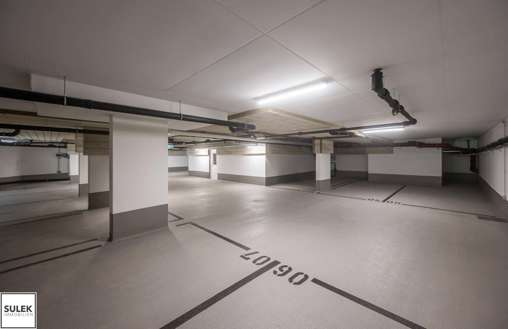 Geräumige Tiefgarage mit markierten Stellplätzen und guter Beleuchtung, bietet sichere Parkmöglichkeiten.