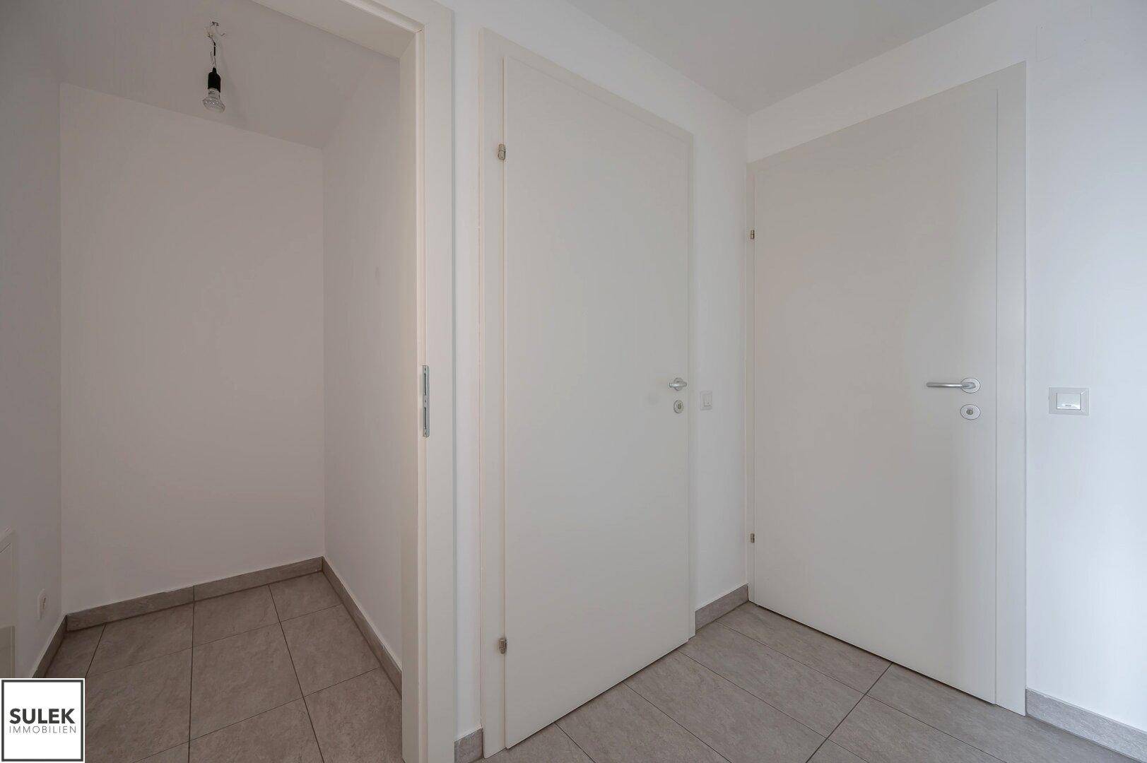 Kleiner Abstellraum mit Fliesenboden und weiß gestrichenen Wänden, ideal für zusätzlichen Stauraum.