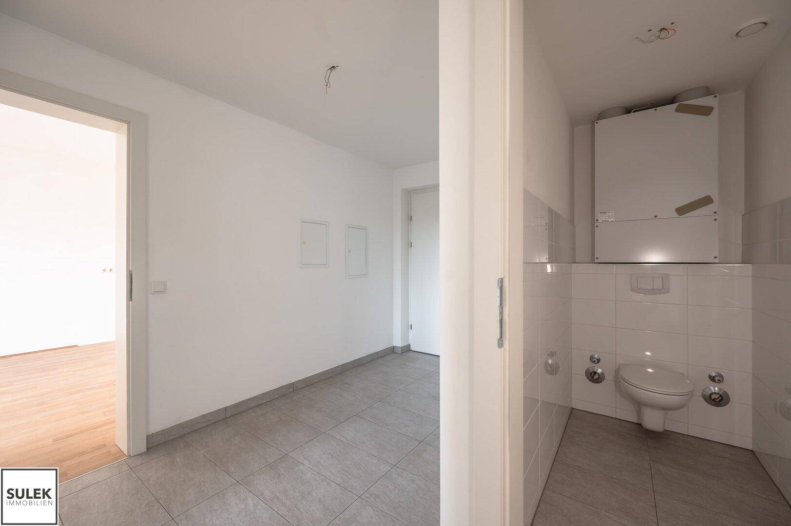 Kleines Gäste-WC mit Wand-WC und weißen Fliesen, funktional und sauber.