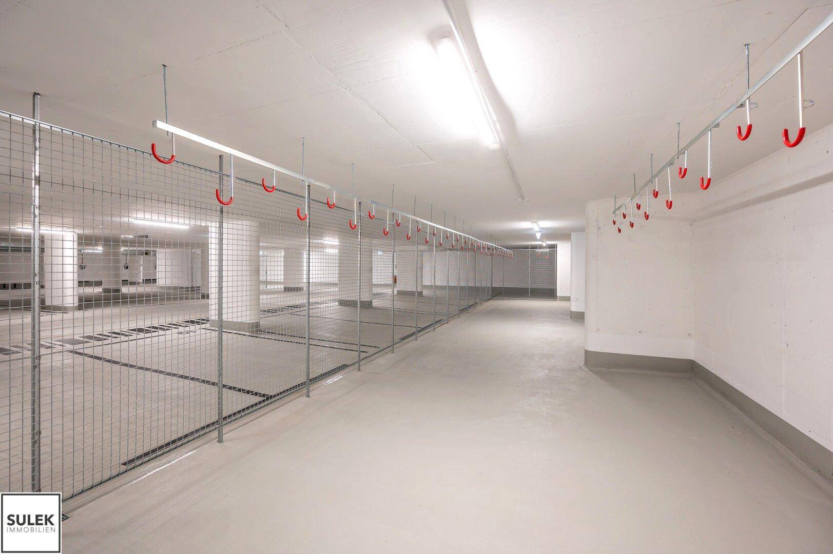 Geräumiger Fahrradraum im Untergeschoss mit vielen Aufhängemöglichkeiten und Metallabtrennungen.