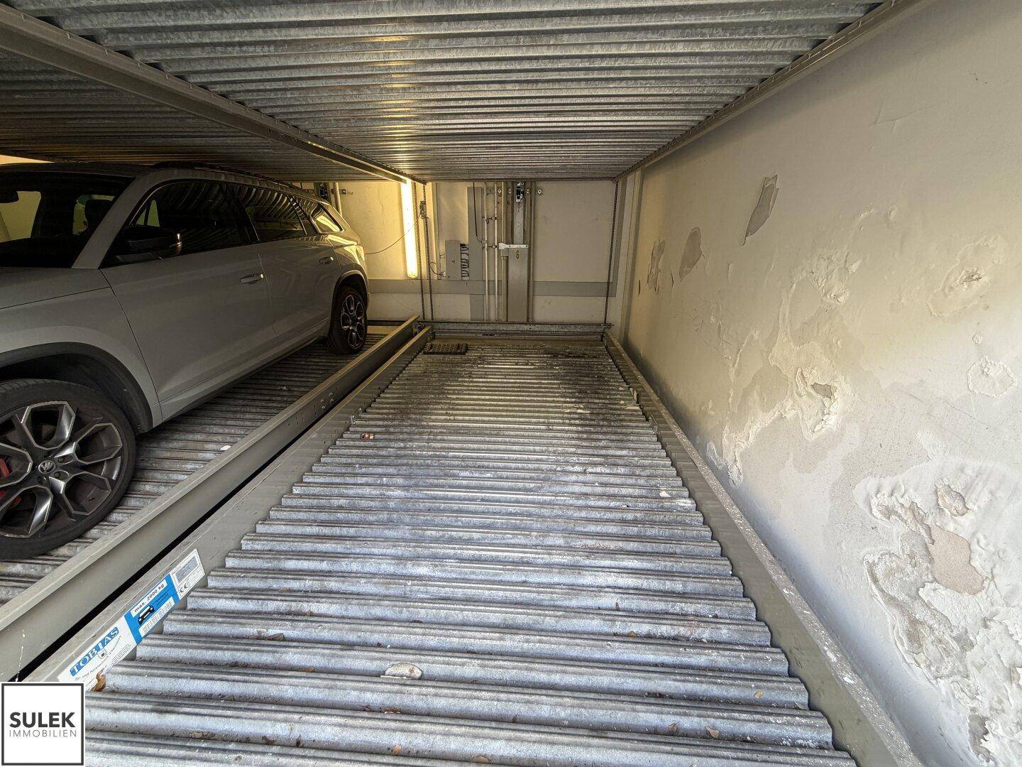 Nahaufnahme des mechanischen Parksystems mit einer Parkplattform und einem geparkten Fahrzeug.