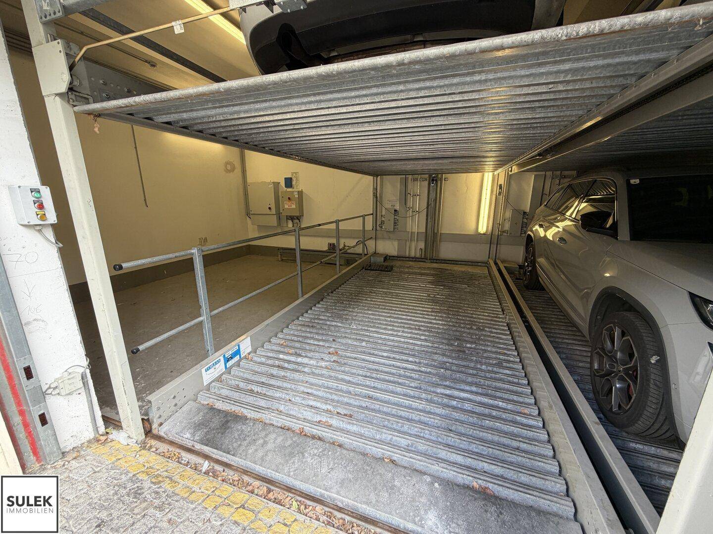 Innenansicht des mechanischen Parksystems mit leerer Plattform und Steuerungselementen.