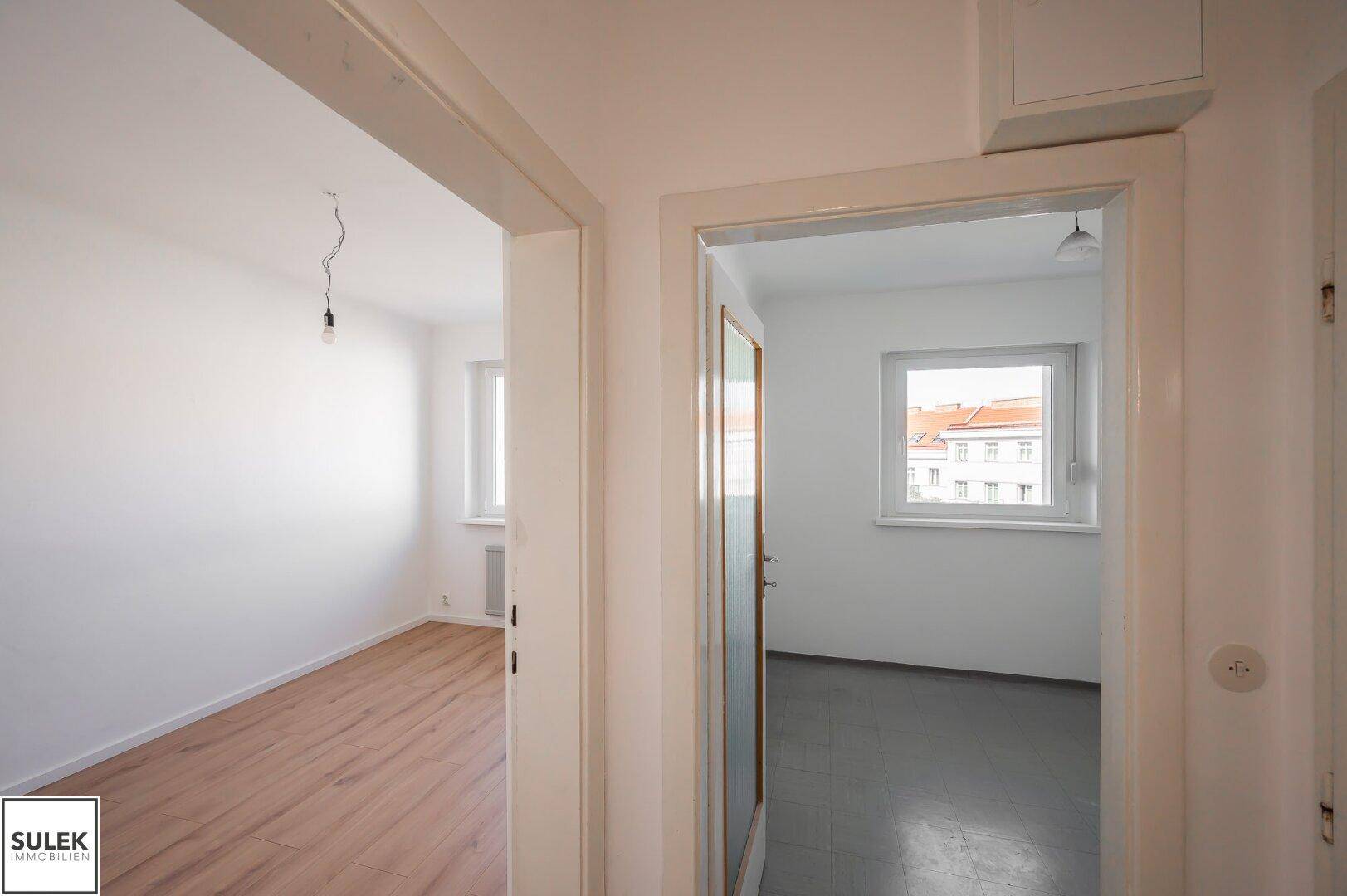 Heller Flur mit mehreren Türen, der verschiedene Zimmer der Wohnung miteinander verbindet.