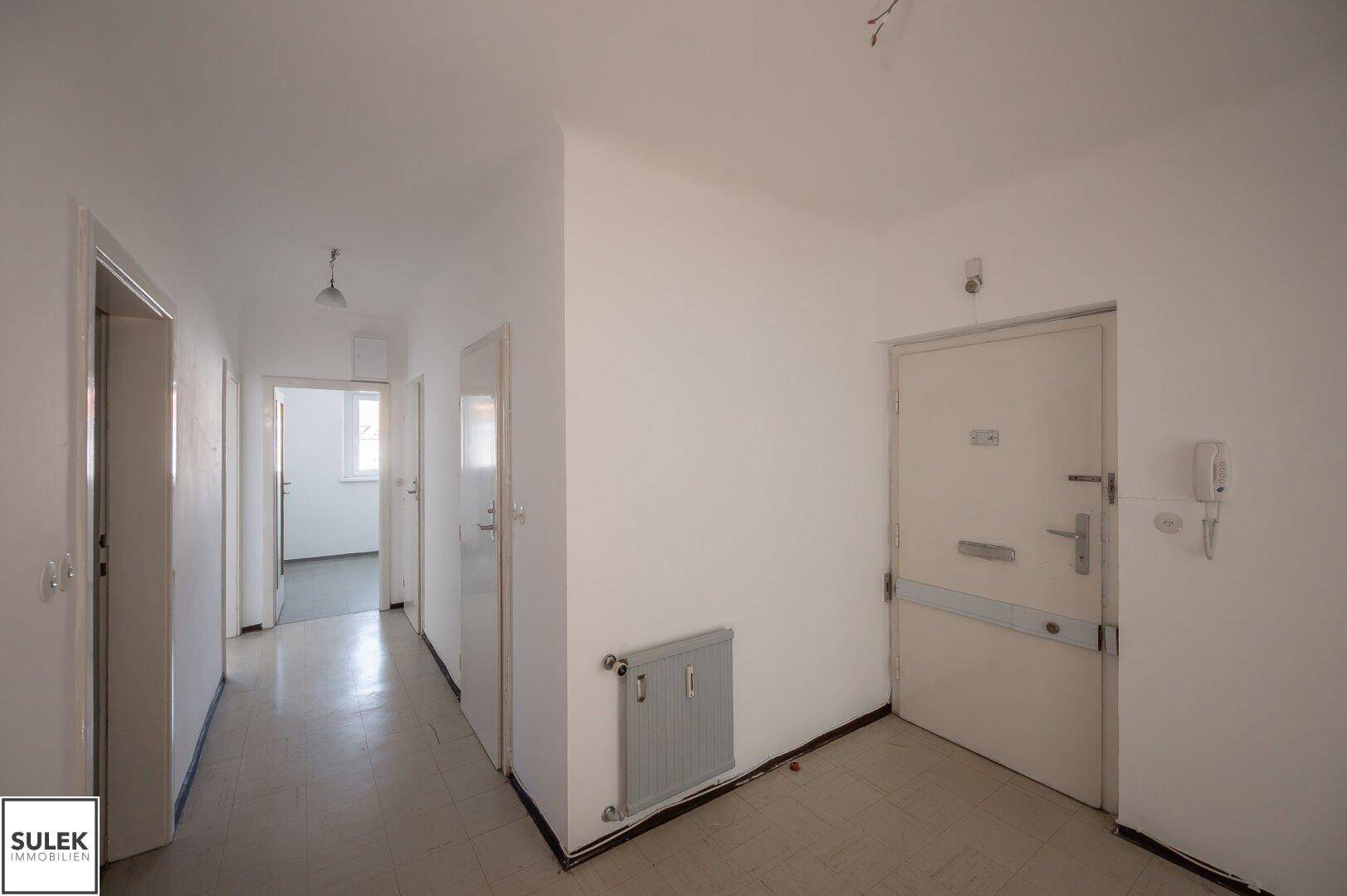 Geräumiger Eingangsbereich mit mehreren Türen und Gegensprechanlage, hell und funktional.