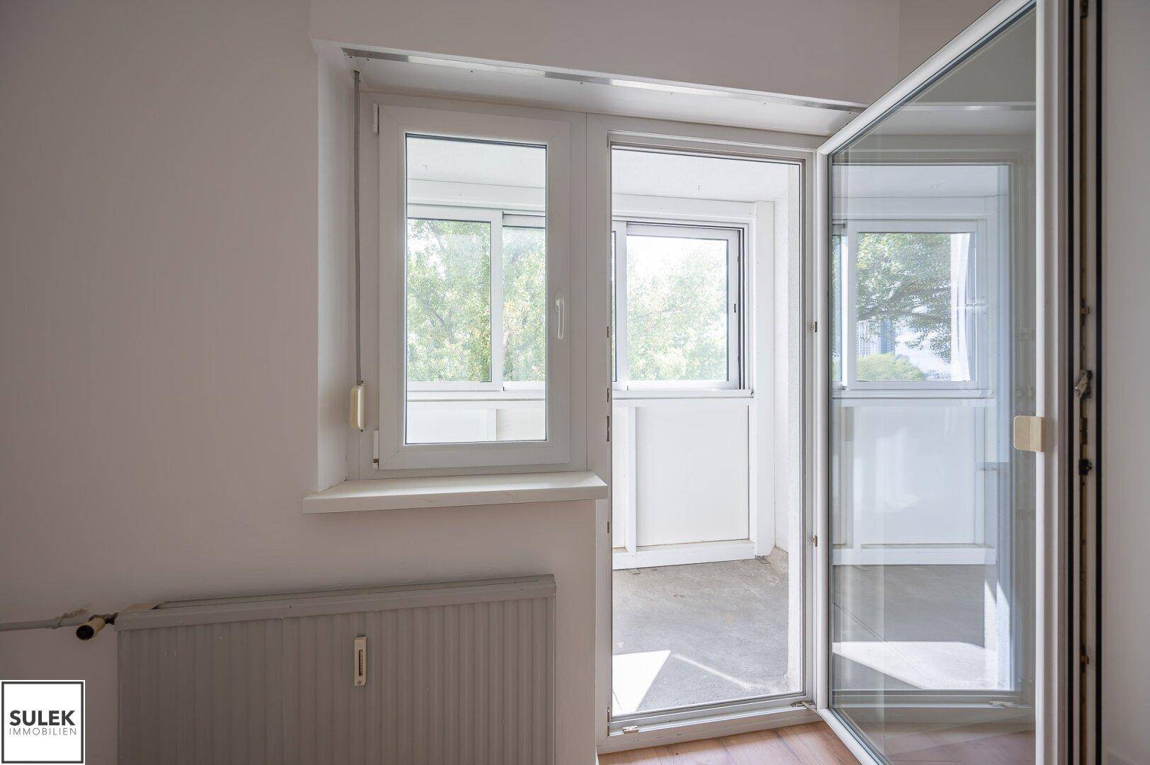 Fenster und Balkontür mit Heizkörper, die viel Licht in den Raum lassen.