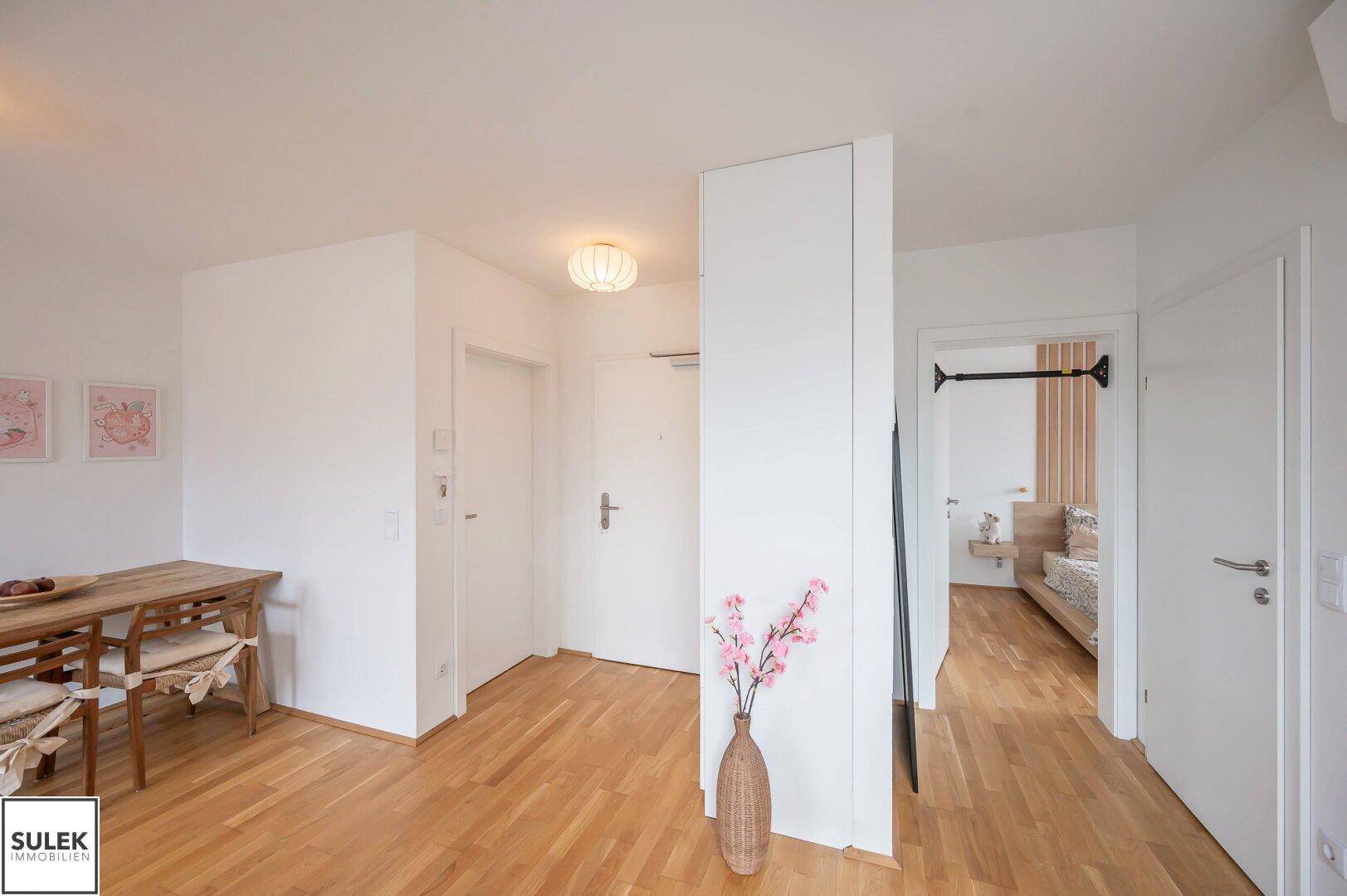 Heller Flur mit Essbereich und Blick in das angrenzende Schlafzimmer.