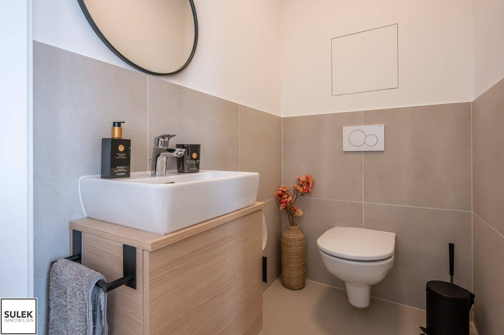 Modernes Gäste-WC mit wandhängender Toilette und stilvollem Waschtisch.